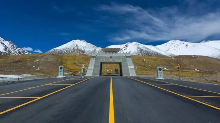 Road leading to the Khunjerab Pass border gate with snow mountains behind